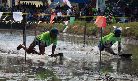 Peserta lomba skilot saling berkejaran untuk menjadi pemenang di kolam arena skilot, Desa Tambak Lekok Kecamatan Lekok, Kabupaten Pasuruan yang dikerumuni ratusan penonton, Rabu (13/7). [hilmi husain]