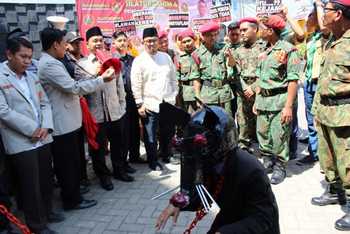 Ketua DPRD dan Ketua PP Muhammadiyah berorasi sambil melihat penangkapan tikus sebagai simbol koruptor. [achmad suprayogi/bhirawa]