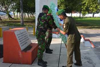 Kasrem 082/CPYJ, Letkol Arh Supyan MT sedang meletakan karangan bunga di depan monumen makam pahlawan Mojokerto. Sementara foto lain tampak segenap anggota kodim bersih- bersih TMP. [hasan amin/bhirawa]