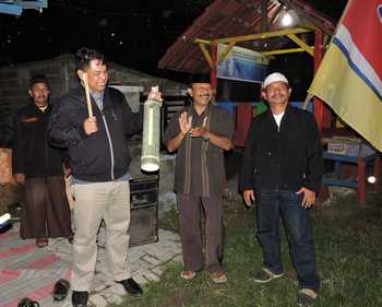 Kapolres Situbondo AKBP Puji Hendro Wibowo dengan didampingi Kapolsek Kota dan Camat Kota Samad saat menyerahkan kentongan, di Pos Kamling Desa Kalibagor, kemarin malam. (sawawi/bhirawa).