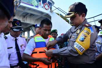 Kapolres Situbondo AKBP Puji Hendro Wibowo saat menyerahkan rompi pengaman kepada petugas di Pelabuhan Jangkar, Situbondo. [sawawi/bhirawa]