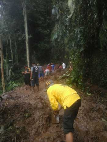 Personel Polisi bersama personil BPBD, PMI, Muspika Ampelgading bersama masyarakat saat membersihkan timbunan lonsoran tanah di Desa Lebakharjo, Kec Ampelgading, Kab Malang.