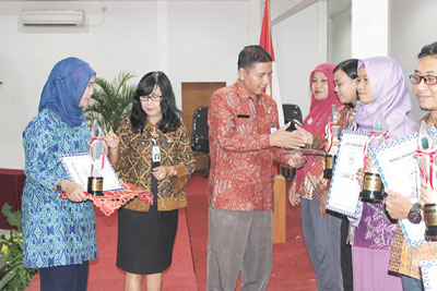 Kabid PNFI Dindik Jatim Nasor SH,MM didampingi Kasie Dikmas Ninik Astuti Dewantari menyerahkan trophy juara kepada para pemenang lomba keberaksaraan tingkat Provinsi Jatim.