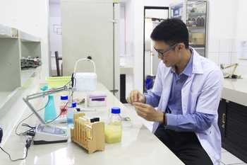 Kenny Jeremia melakukan uji coba di Laboratorium Bioteknologi Mikroorganisme Ubaya menggunakan air dari Kawah Ijen yang diketahui mengandung mikro organisme. [ adit hananta utama/bhirawa]