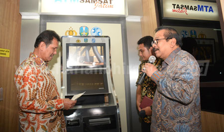 Gubernur Jatim Dr H Soekarwo memamerkan salah satu inovasi layanan publik berbentuk ATM Samsat Jatim kepada Menpan dan RB Asman Abnur saat kunjungan kerja ke Jatim, Selasa (2/8).