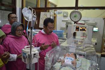 Wakil Bupati Gresik, Moh Qosim saat menjengguk bayi berkepala dua di RS Ibnu Sina. [kerin ikanto/bhirawa]