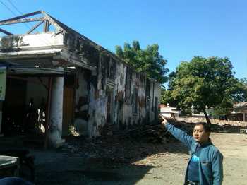 Salah satu aktivis LSM Wirabhumi meninjau rehab gedung bangunan cagar budaya di selatan alun-alun Kecamatan Asembagus, kemarin. [sawawi/bhirawa]