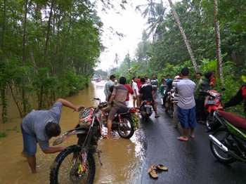 Sebagian sepeda motor mogok ketika pengendaranya nekad menembus air banjir yang juga membawa lumpur di jalan raya Desa Bantengan dan Desa Talun, Kecamatan Bandung, Tulungagung, Rabu (17/8).
