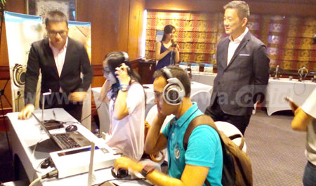 Vic President, Sales & Marketing Sennheiser Asia, Martin Low saat melihat pengunjung mencoba headphone Sennheiser. [achmad tauriq]
