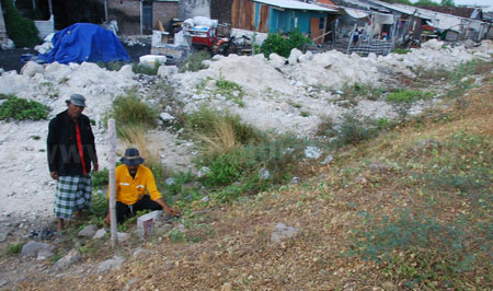 Warga Keputih Timur Pompa Air, Kelurahan Keputih Sukolilo mengecek patok yang tertancap di tanah kawasan pemukimannya, Rabu (21/9). [gegeh bagus setiadi]
