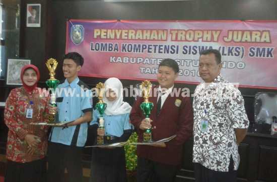 Kasek SMKN I Panji, Dra Kumudawati, MPd, saat menerima piala juara umum ajang LKS 2016 kemarin. [sawawi/bhirawa]