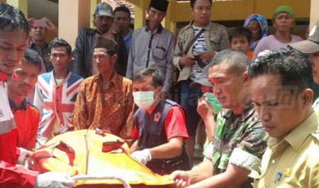 Usai ditemukan korban banjir dibawa ke Balai Desa Palenggiyan  Kecamatan Kedundung dan dibawa ke mobil ambulans menuju Puskesmas setempat untuk diautopsi, Senin (26/9). [nur cholis]