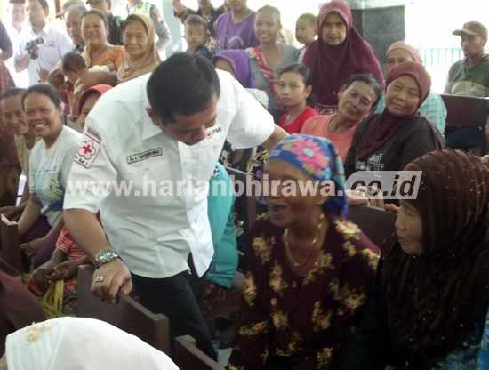 Ketua Cabang PMI Nganjuk, Drs H Taufiqurrahman menyapa dan membagikan sembako kepada lansia yang kurang mampu di Desa Balongpacul, Nganjuk.(ristika/bhirawa)