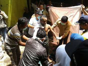 Srihadi penderita gangguan jiwa saat dikeluarkan oleh petugas Dinsos dan RSJ Lawang dari ruang pemasungan, di Jalan Penarukan, Kel Penarukan, Kec Kepanjen, Kab Malang.