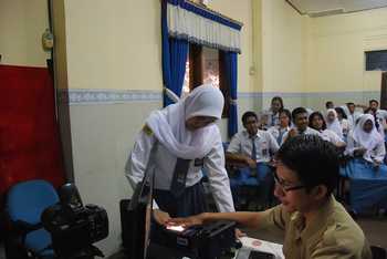 Salah satu siswi kelas XI SMA Negeri 1 Surabaya menjalani perekaman iris mata oleh petugas Dispendukcapil Surabaya, di ruang multimedia sekolahnya, Senin (31/10) kemarin. [Gegeh Bagus Setiadi/bhirawa]