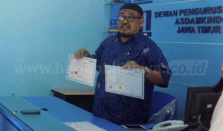 Ketua Aspekindo Jatim Saleh Ismali Mukadar menunjukkan contoh SBU dan sertifikat keahlian yang harus dimiliki setiap pengusaha jasa konstruksi dan tenaga kerja sektor konstruksi. [adit hananta utama]