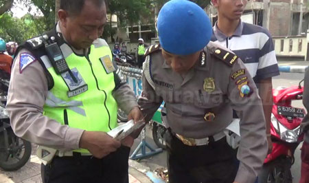 Petugas Propam Polres Jombang melakukan pemeriksaan terhadap anggota Satlantas Polres Jombang yang sedang menggelar oeprasi di simpang empat Alun alun Jombang, Kamis (20/10). [ramadlan]