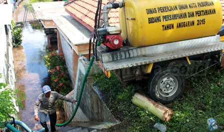 Petugas PU Kota Pasuruan menyedot air banjir beberapa waktu lalu yang merendam ratusan rumah warga di Kelurahan Blandongan Kecamatan Bugul Kidul Kota Pasuruan. Penyedotan air dilakukan agar air banjir cepat surut. [hilmi husain]
