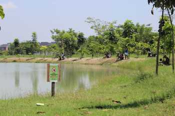 Puluhan warga nekat memancing di waduk penampungan air hutan kota Balas Klumprik, Minggu (16/10) meski ada plakat dilarang memancing. [Gegeh Bagus Setiadi/bhirawa]