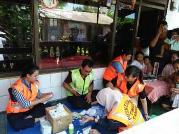 Petugas kesehatan dari Puskesmas Taman melayani obat - obatan untuk warga Desa Ketegan Kec Taman, yang jadi korban banjir.  [Ali kusyanto/bhirawa]