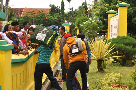 Salah satu jamaah rela melompat pagar Pendopo Kabupaten Jombang agar segera bisa bertemu keluarga mereka, Rabu (5/10). 