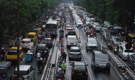 Kerusakan lampu TL di beberapa ruas jalan ditambah guyuran hujan deras memacetkan Surabaya, Rabu (30/11). [trie diana]