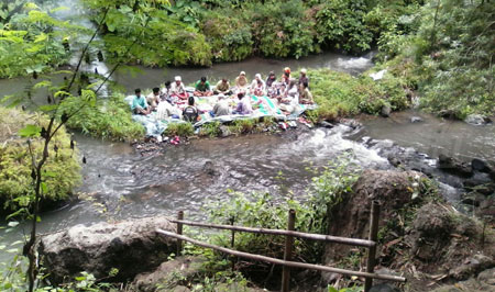Warga Desa Ramban Kulon menggelar selamatan dan makan bersama di tengah sungai untuk menyelamatkan sumber mata air demi kesuburan tanah, Selasa (15/11). [samsul tahar]