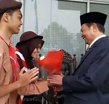 Wali Kota Mojokerto Mas'ud Yunus mendapat kejutan buket bunga dari dua orang pelajar sebelum upacara hari guru. [kariyadi/bhirawa]