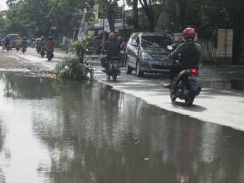 Lalulintas di Jl Abdul Fatah Barat Kota Tulungagung terganggu akibat penanaman pohon dan sisa air hujan yang masih menggenang, Selasa (22/11)