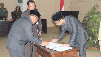 Bupati Bondowoso Drs H Amin Said Husni dan Ketua DPRD Bondowoso H Achmad Dhafir menandatangani penetapan Raperda menjadi Perda. (Samsul Tahar/Bhirawa)