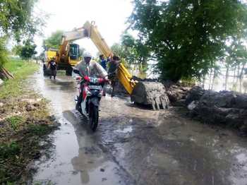 Datangkan alat berat dan warga saat perbaiki tanggul Desa Temu, Kecamatan Kanor, Bojonegoro akibat terdampak bajir luapan bengawan solo. (achmad basir/bhirawa)