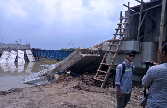 Petugas ketika memeriksa konstruksi Jembatan-Rejoso-yang dianggarkan Rp 40 M ternyata bisa ambruk. [kariyadi/bhirawa]