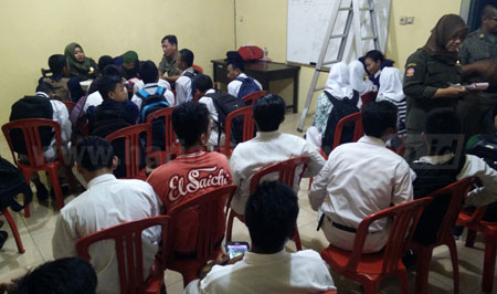 Petugas Satpol PP Kota Pasuruan mendata puluhan pelajar yang terjaring razia saat jam belajar berlangsung, Selasa (13/12). [Hilmi Husain]