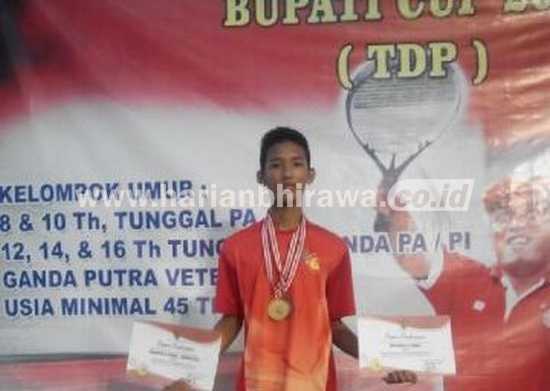 M. Al Furqan saat menerima medali perunggu dan medali emas untuk ganda pada kejuaraan cabor tenis lapangan junior di Tulungagung, baru-baru ini. (sawawi/bhirawa)