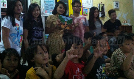 Keenam mahasiswa UK Petra Jurusan DKV foto bersama puluhan anak-anak eks Lokalisasi Dolly di Taman Bacaan Masyarakat (TBM) RW 11 Putat Jaya, Kamis (1/12) kemarin. [gegeh bagus setiadi]
