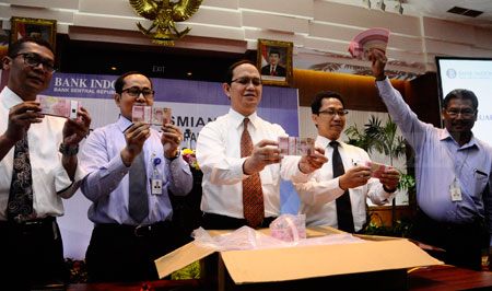 Petugas memperlihatkan uang kertas baru TE 2016 di Kantor Perwakilan Bank Indonesia (BI) Jatim di Surabaya, Senin (19/12). Sebanyak 11 pecahan uang baru diluncurkan, tujuh dalam bentuk uang kertas dan empat berupa koin.