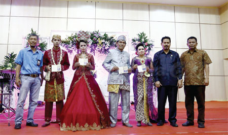 Pasangan menunjukkan buku nikah setelah mengikuti acara nikah massal yang digelar Pemkot Surabaya di Gedung Convention Hall Jl Arief Rahman Hakim, Rabu (21/12).