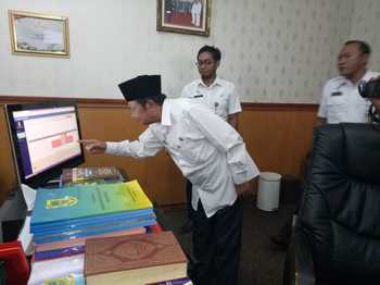 Wali Kota Mojokerto, Mas'ud Yunus memantau absensi PNS dari monitor di ruang kerjanya, Rabu (28/12) kemarin. [kariyadi/bhirawa]