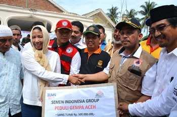 Menteri BUMN, Rini M Soemarno menyerahkan bantuan secara simbolis kepada Bupati Pidie Jaya, Aiyub Abbas, disaksikan Direktur Enjiniring dan Proyek PT Semen Indonesia (Persero) Tbk, Gatot Kustyadji (kanan).