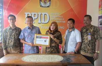 Komisioner KPU dan Sekretaris KPU Tulungagung, Lilik Wijayanti MH, memperlihatkan sertifikat yang diberikan KIP Jatim, Rabu (14/12)