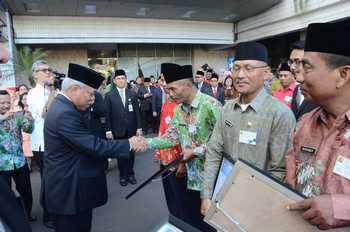 Rohamin saat berjabat tangan dengan Menteri PUPR Basuki Hadi Mulyono untuk menerima hadiah motor di Jakarta. (Samsul Tahar/Bhirawa)