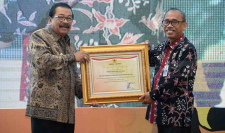 Gubernur Jatim Dr H Soekarwo menyerahkan penghargaan AKIP kepada Anom Surahno SH, MSi mewakili Biro Humas dan Protokol Setdaprov Jatim yang mendapatkan Kategori BB atau Sangat Baik, Selasa (6/12).