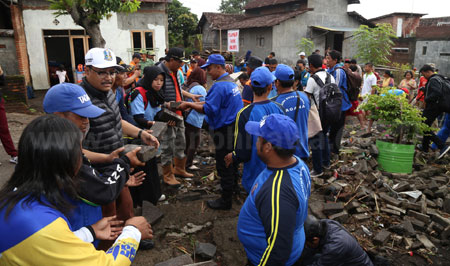 Wakil Gubernur Jatim Drs H Saifullah Yusuf ikut membantu mengumpulkan paving jalan kampung yang porak-poranda diterjang banjir bandang di Puwodadi Kabupaten Pasuruan.