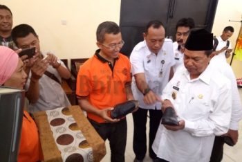 Wali Kota Mas'ud Yunus memeriksa kualitas sepatu produk UMKM kota Mojokerto yang akan diperuntukkan bagi siswa setingkat SD hingga SMP secara gratis. (kariyadi/bhirawa)